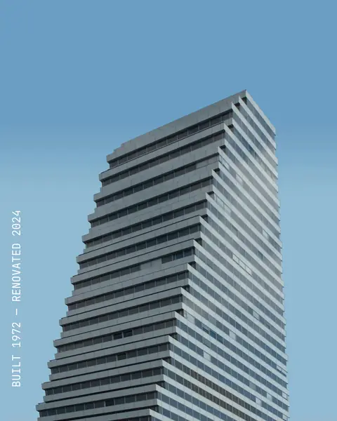 A ribbed tower against a blue sky, with “Built 1972 — renovated 2024” running vertically up the left edge