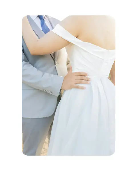A detail of an embrace in soft daylight, set on a white 4:5 background with the photograph’s corners rounded