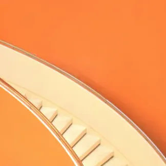A pale staircase curving against a bright orange wall