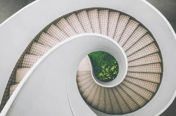 A spiral staircase from above, filling a wide landscape frame