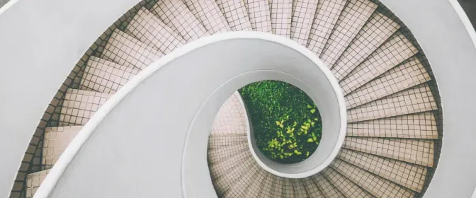 A spiral staircase seen from above, its curve sweeping across the full width of the frame