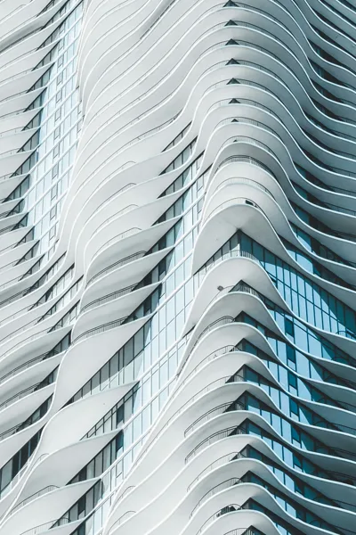 Undulating balcony slabs stacked up the side of a glass tower